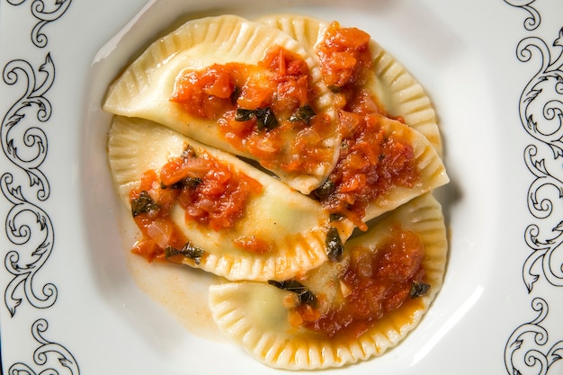 Dumplings with meat with tomato on a plate - Pierogi