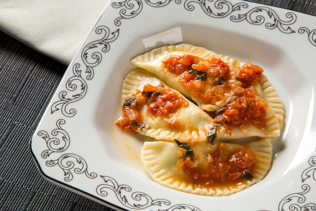 Dumplings with meat with tomato on a plate - Pierogi