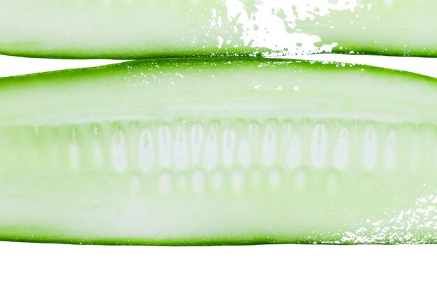 Dun gesneden in de lengte gesneden plakjes verse groene komkommer op een witte achtergrond