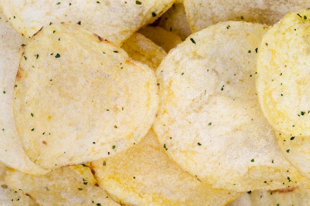 Dunne chips met kruiden en zout, chips gebakken in olie en besprenkeld met kruiden, schadelijk fastfood