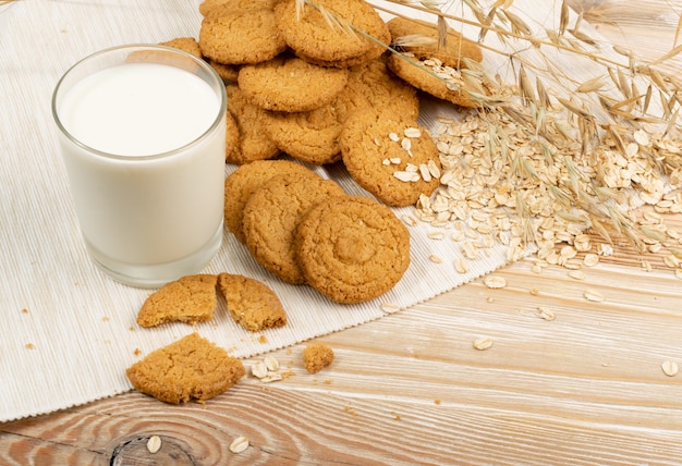 Dunne havermoutkoekjes of gezonde havermoutcrackers met melk. Krokant anzac-koekje met havervlokken op rustieke tafelachtergrond