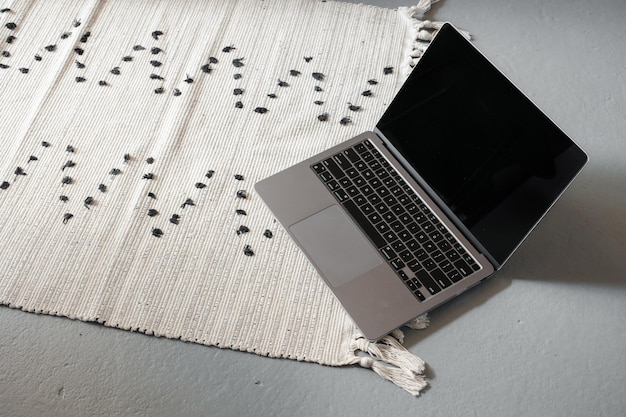 Dunne laptop op grijze vloerachtergrond