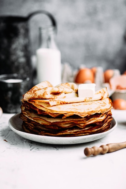 Foto dunne pannenkoeken met melk in een bord. pannenkoeken