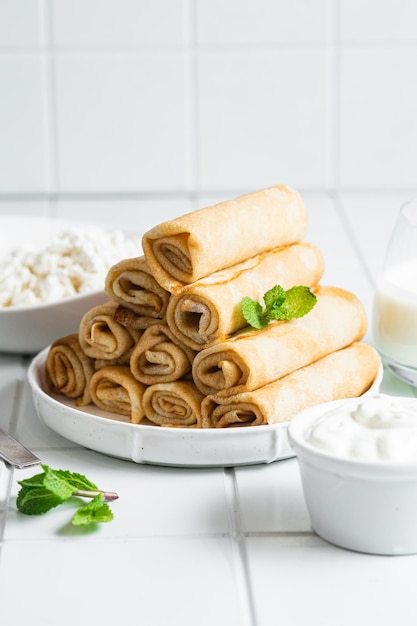 Dunne pannenkoekjes met kruiden, zalm en roomkaas op een bord