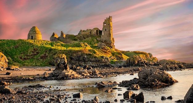 Dunure Castle surrounded by the sea during the sunrise in Scotland