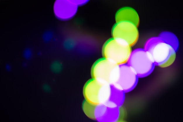 Luci al neon sfocate bicolore verde e viola su fondo nero. concetto di festa notturna.