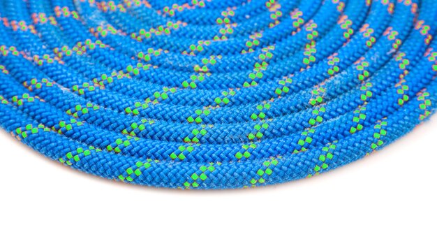 Durable colored rope for climbing equipment on a white background coil of braided cable item for tourism and travel