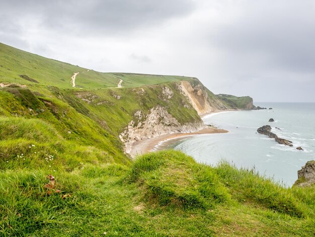 Dorset England의 주변 절벽 해안선이 있는 해안선의 Durdle 도어 천연 석회암 아치