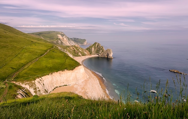 Скальная арка Durdle Door на Дорсетском побережье Юрского побережья в Англии на закате