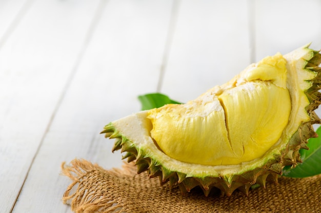 Il durian e il durian sbucciano un mese sul sacco e sullo sfondo di legno vecchio