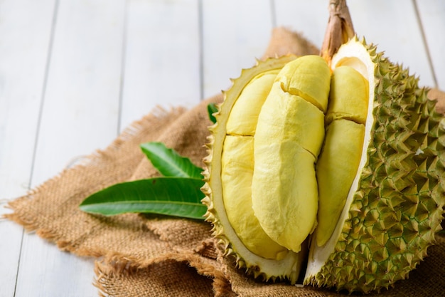 Durian fruit Ripe monthong durian on sack and white wood background
