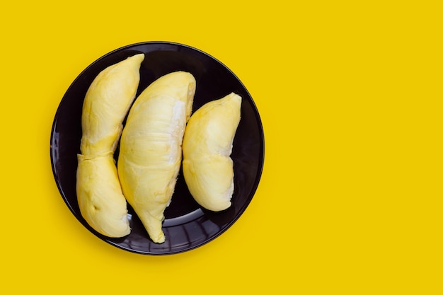 Durian  in plate on yellow background.