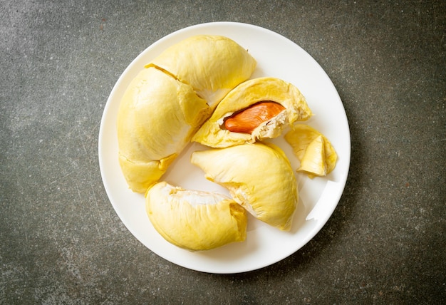 Durian maturato e fresco, buccia di durian su piatto bianco