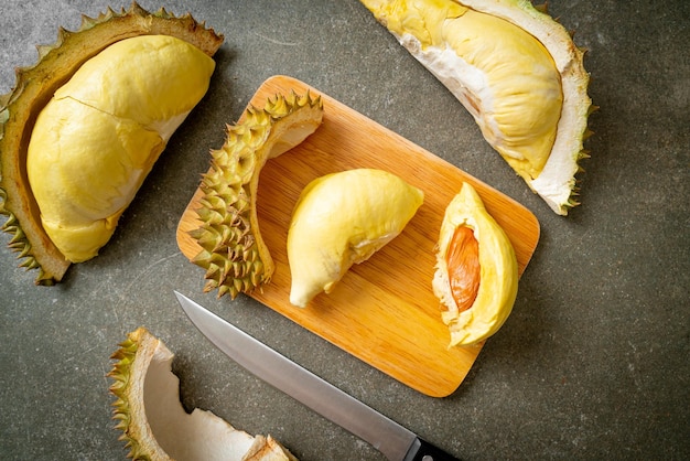 Durian maturato e fresco, buccia di durian su tavola di legno