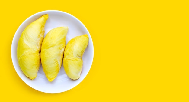 Durian in white plate on yellow surface