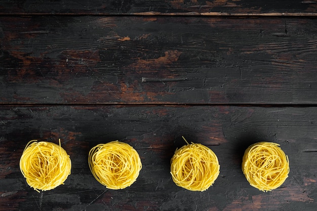 Durum wheat semolina homemade egg pasta tagliarini set, on old dark  wooden table, top view flat lay, with copy space for text