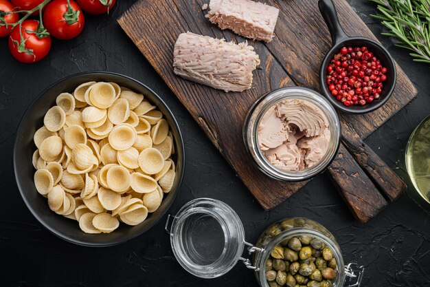 Durumtarwe griesmeel tonijn pasta ingrediënten op zwart, bovenaanzicht