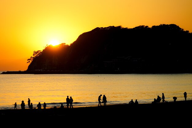 Photo dusk and the people of the silhouette of kamakura coast