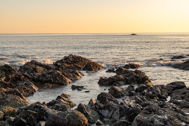 夕暮れ時に、海岸の海が岩を叩きました