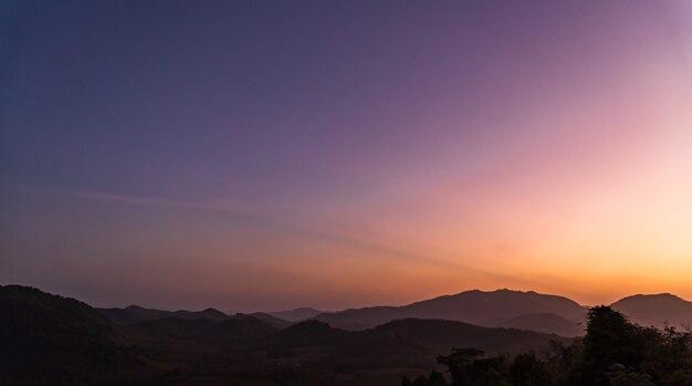 夕暮れの夕方のシルエットの山の上の夕暮れの空