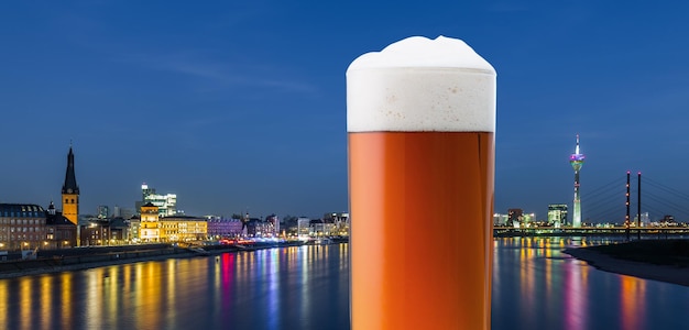 Фото Горизонт города дюссельдорфа со старым пивом в стакане