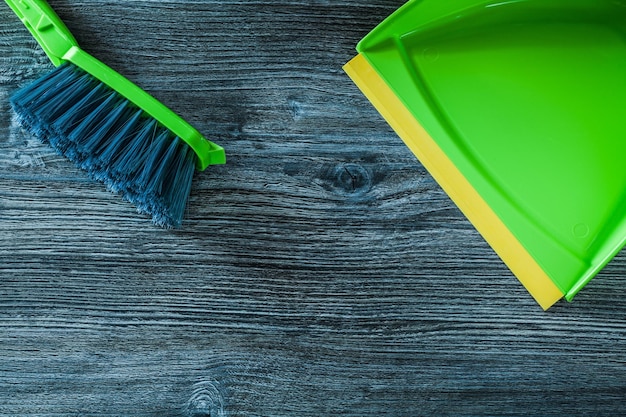 Dustpan and garbage broom set on wooden board