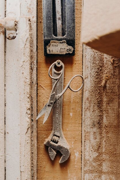 Dusty work tools hang over wooden panel