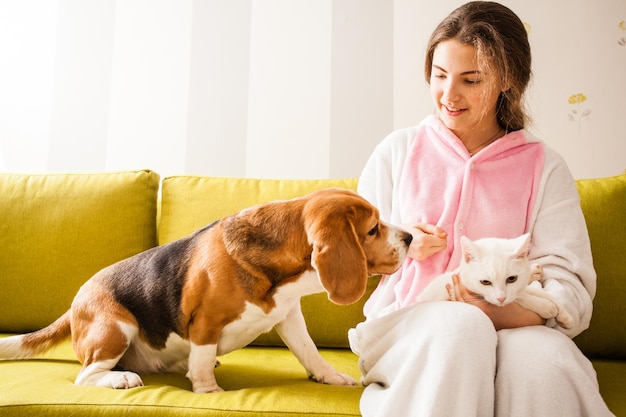 Dutiful pets are sitting with the girl on the sofa