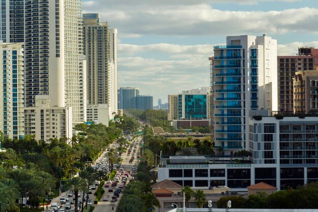 Duur hoogbouw hotels en appartementen aan de atlantische oceaan kust in sunny isles beach stad en drukke straat verkeer amerikaanse toerisme infrastructuur in het zuiden van florida