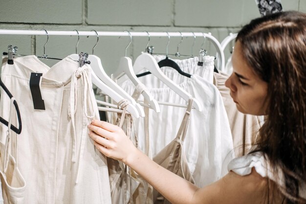 Foto duurzame mode langzame mode close-up opname van vrouwelijke hand het nemen van kleding rack met natuurlijke