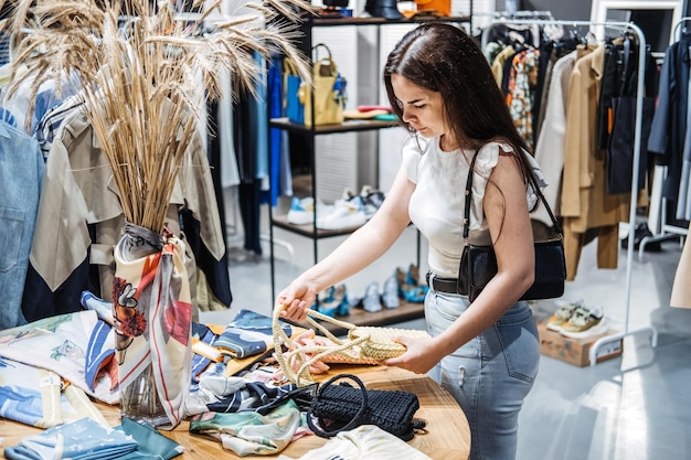 Duurzame mode moderne latina jonge vrouw die handgemaakte gebreide handtas kiest in een milieuvriendelijke winkel