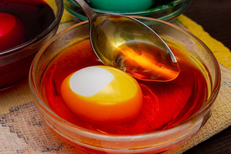 Photo dying yellow egg for easter in glass jar