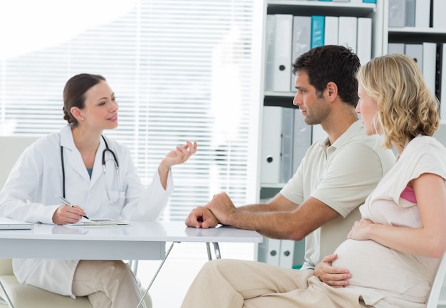 Dynaecologist discussing with expectant couple