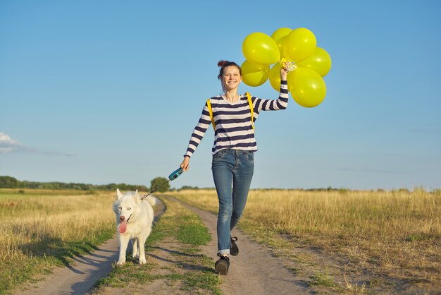 Dynamisch openluchtportret van het runnen van meisje met witte hond