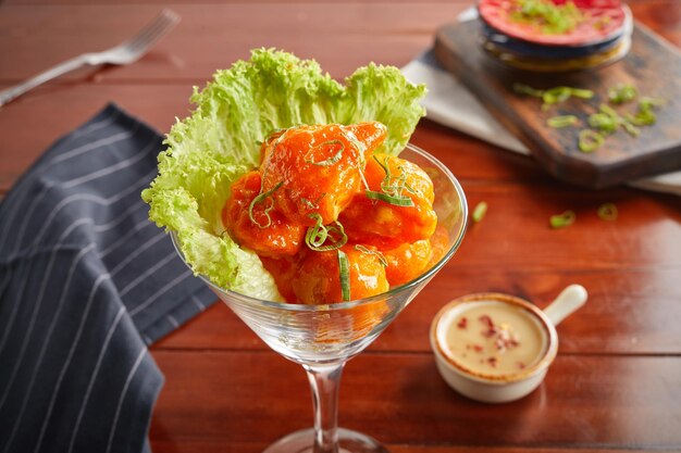 Dynamite egg with dip served in a goblet isolated on wooden background side view