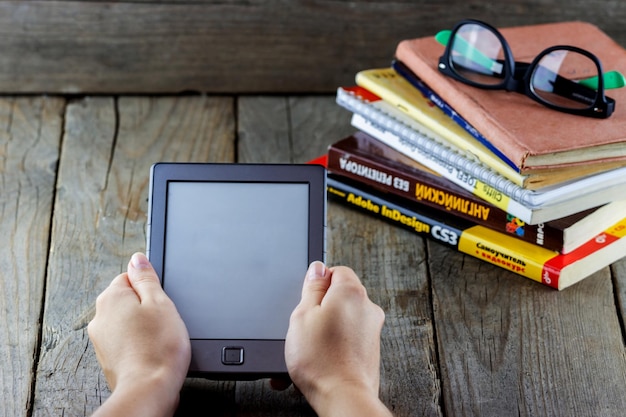 E-book in the hands of a reader with old books