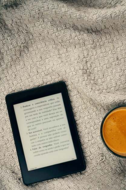 E-book reader, een kopje koffie en een koptelefoon.