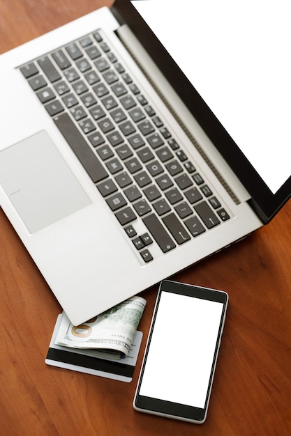 E-commerce advertisement. Laptop computer and phone with white screen. Modern technology