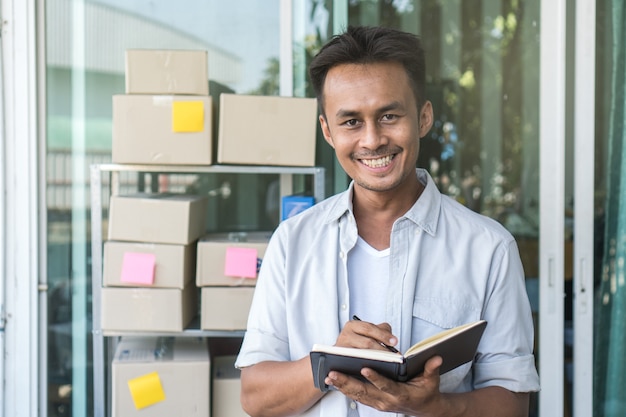 E-commerce business owner reviewing checklist of customer before sent box of product by pa