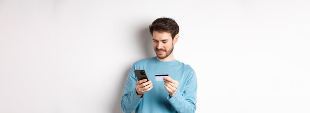 E-commerce en winkelconcept glimlachende man bestel online kopieer creditcardnummer naar app voor mobiele telefoon