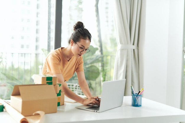 E-commerce zakenman werkt aan een laptop en bereidt deze voor op levering op kantoor