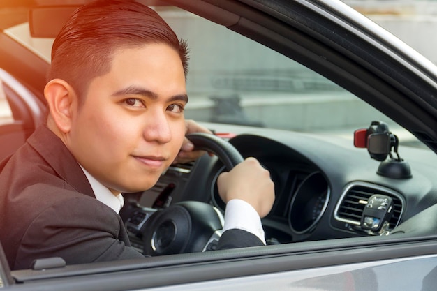 E-ヘイリングコンセプト アジアの若い男性が車を運転している