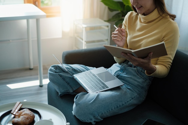 E-learning online onderwijs en internet sociale afstand beschermen tegen COVID19-virussen concept Aziatische vrouw student videoconferentie e-learning met leraar op laptop thuis