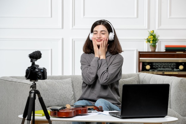 E-learning op afstand thuis vioollessen geven jong schattig mooi meisje in koptelefoon