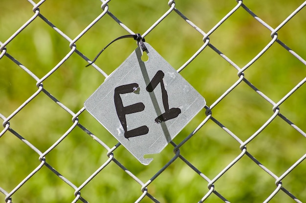 E1 Tagged Chain Link Fence with Green Background