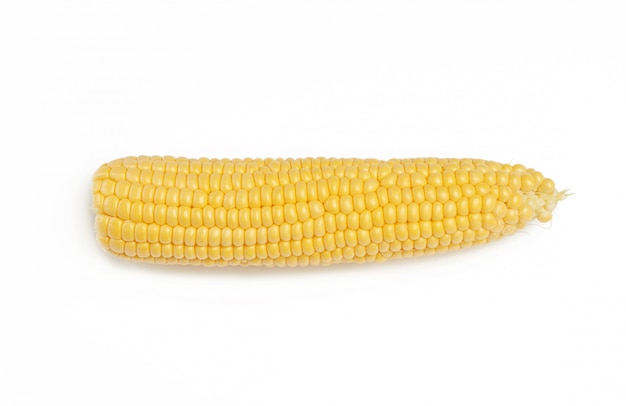 Ear of corn with yellow seeds peeled from green leaves isolated on white background