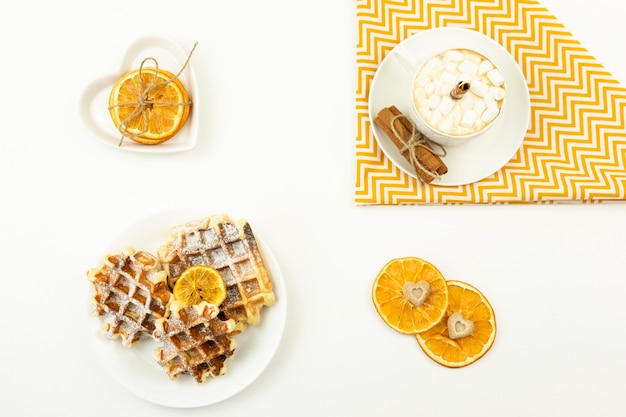 Early breakfast coffee with marshmallows and a stick of cinnamon and Belgian waffles