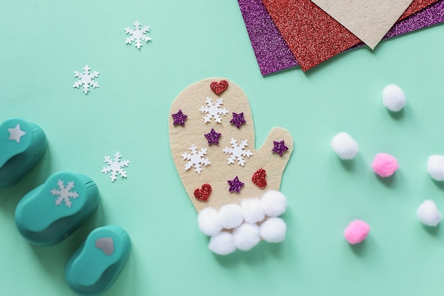 Early DIY ideas winter mitten from pom pon felt figured hole punch Doublesided tape  Step 2