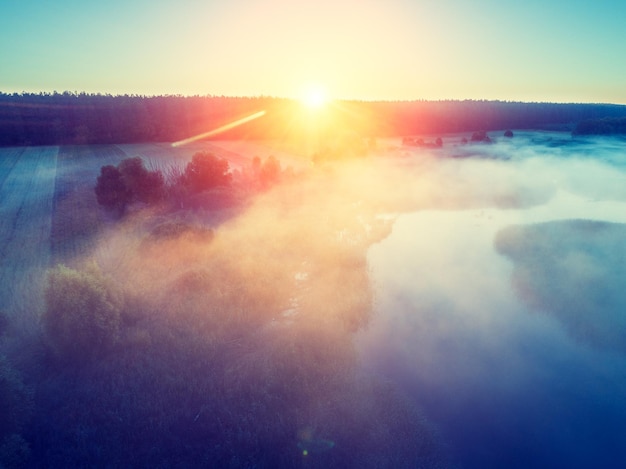 Early misty morning Aerial view of countryside and river The sun highlights the fog over the river