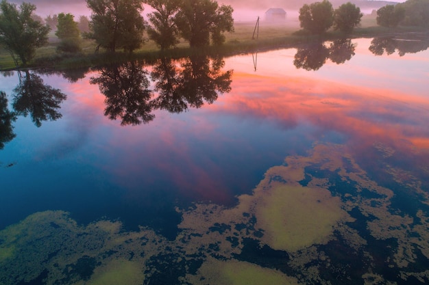 Early misty morning sunrise over the lake Rural landscape in summer Aerial view